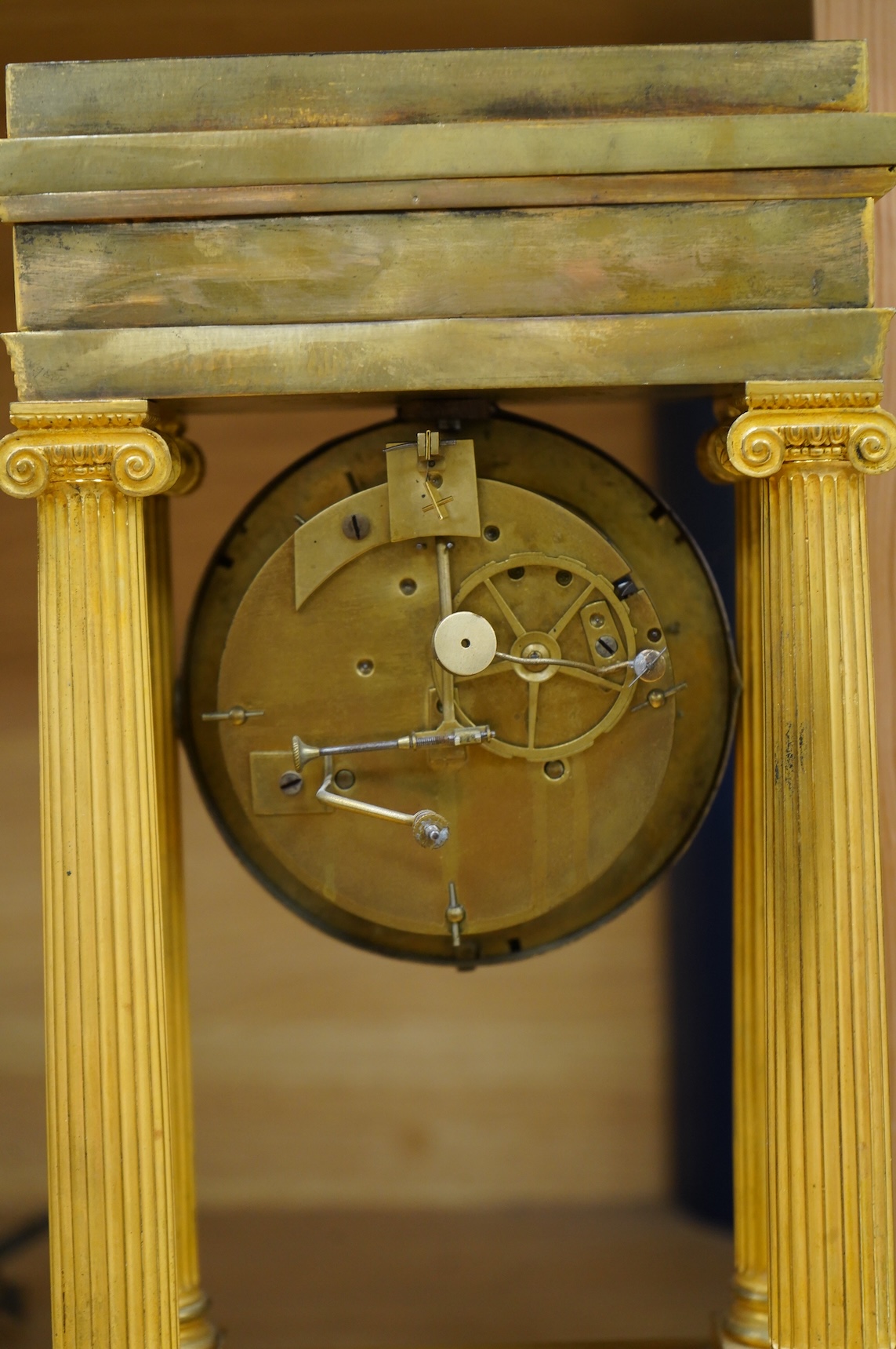 A 19th century French gilt brass eight day portico clock with pendulum, 38cm